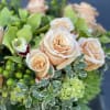 A darling arrangement with amazing taupe and peach roses in a leaf-lined
