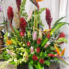 Large display of Tropical flowers softened with roses and lilies. Prefect for