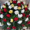 A beautiful combination of yellow roses, red/white carnations together with lush greenery