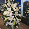 All white lilly and rose standing spray a beautiful tribute to any