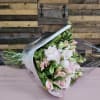 This charming hand-tied bouquet showcases a delicate mix of blush pink roses