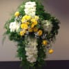 A cross containing simply elegant white flowers is adorned with a large
