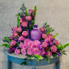 Monochromatic urn spray pictured in varying shades of purple including roses, mums