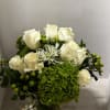 White roses and green hydrangeas in a square vase 