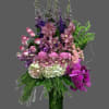 Nice mix of lavender and purple flowers in a tall cylinder vase.