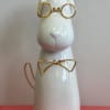 This charming white ceramic dog figurine features golden wire glasses and a