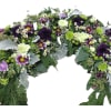 Elevate your memorial tribute with our stunning floral arrangement, featuring rich purple