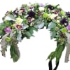 Elevate your memorial tribute with our stunning floral arrangement, featuring rich purple