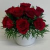 A luscious mix of red roses and greens delivered in a white