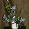 The &quot;Dagon&quot; floral arrangement features a mix of green chrysanthemums, blue delphiniums