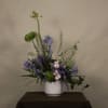 The &quot;Dagon&quot; floral arrangement features a mix of green chrysanthemums, blue delphiniums