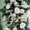Fresh white flowers and touches of green foliage for a peaceful tribute.