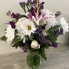 White daisies, pink lilies, purple statics, and fuchsia stock.