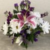 White daisies, pink lilies, purple statics, and fuchsia stock.