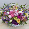 This basket is filled with variety of pastel roses and ranunculus and