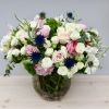 This round vase is filled with a bouquet of white spray rose