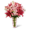 Hand-arranged to perfection within a pink glass vase, this pink lilies arrangement