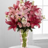 Hand-arranged to perfection within a pink glass vase, this pink lilies arrangement