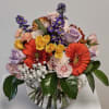 A bright bubble arrangement featuring button mums, gerbera daisies, and spray roses