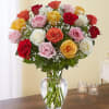 All-around arrangement with 24 long stem multicolor roses; accented with baby&rsquo;s breath