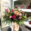 Expertly wrapped in soft-toned paper and tied with an elegant, ruffled ribbon