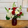 Red roses, white hydrangea, red alstroemeria, white chrysanthemums and white snapdragons arranged