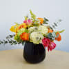 This arrangement is presented in a pinched glass vase and accented by