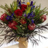 This long lasting arrangement is comprised of proteas, irises, red roses, safari