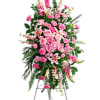 A pink a white standing spray with roses , snap dragons, lilies