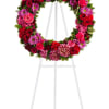 A standing wreath with pink roses and carnations, red roses, lavender chrysanthemums