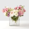 A soft, blush arrangement in pinks and cream featuring roses, lisianthus, mini