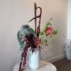 - Vase floral arrangement exuding dramatic allure
- Tall, dark plants standing prominently
-