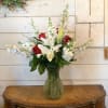 Red roses, white lilies, white delphinium, fragrant white stock, arranged in a