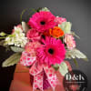 Mixed pink bouquet with accents of white and orange. May include roses