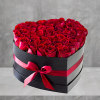 A modern flower arrangement in a heart box filled with red roses.

DETAILS
This
