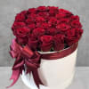 Red roses are beautifully arranged in a white cylinder box. Have them