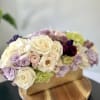 A lush a full arrangement with roses, ranunculus, orchids, hydrangeas and spray