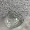 A heart-shaped glass container will hold the red roses and the chocolates