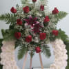 Open wreath with white carnations, red roses, and hot pink lilies.