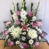 The &quot;Lavender Roses and White Flowers Basket&quot; is a funeral arrangement in