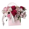 This elegant floral arrangement features soft, blush roses as the centerpiece, their