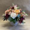 A glorious symphony of warm peach, soft pink, and burgundy with contrasting