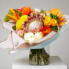 Tropical and exotic flower bouquet with King protea, roses, laceleafs and transvaal