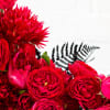A modern ceramic vase, 7 inches in diameter, filled with lush red
