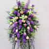 Delphinium, stock, roses and orchids in lavender, green and peach combine to