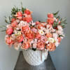 An arrangement with a rose and baby roses typically features a prominent