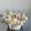 Modern basket full of fresh summer flowers is the perfect gift for