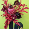 Orchids, Anthuriums, Protea,painted leaves in a black ceramic vase. 