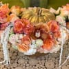 This stunning centrepiece features a fresh pumpkin filled with hydrangeas, roses, spray