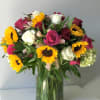This vibrant and warm floral arrangement combines the bold, golden hues of
